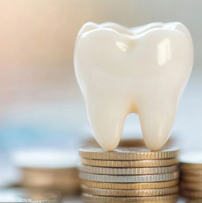 Tooth model sitting on top of coins