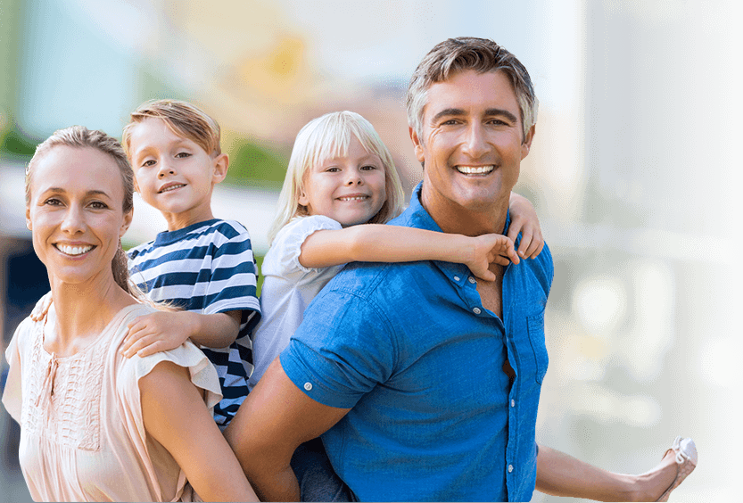 Man and woman giving kids a piggyback ride